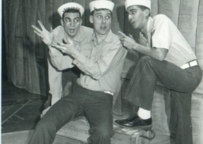 three young sailors from WWII one sitting others leaning on a crate